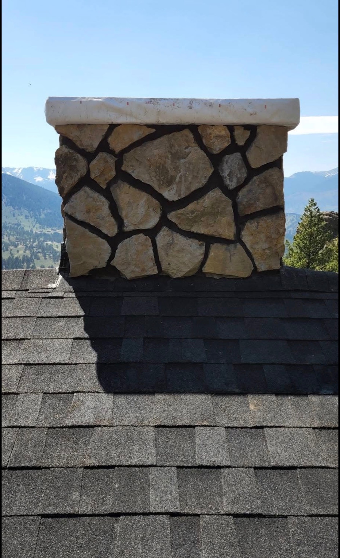 Mountain home stone chimney with panoramic Colorado views